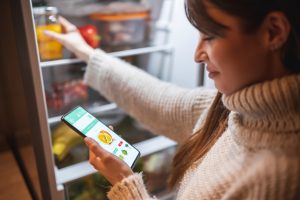 Woman ordering groceries online for home delivery